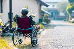 woman in wheelchair in front of her house
